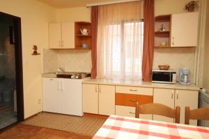 La cuisine est équipée de placards blancs et d'un four micro-ondes. dans l'établissement Apartments and rooms with parking space Porec - 6917, à Poreč