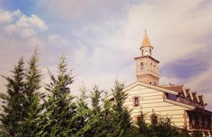a church with a steeple on top of some trees at Spa Complejo Rural Las Abiertas in San Bartolomé de las Abiertas