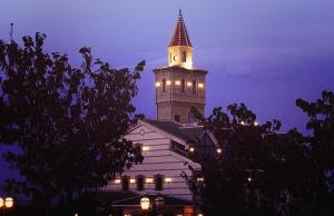 un gran edificio con una torre de reloj por la noche en Spa Complejo Rural Las Abiertas en San Bartolomé de las Abiertas