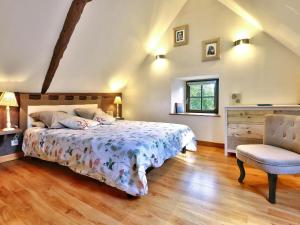 um quarto com uma cama e uma cadeira em Charming holiday home with garden em Huelgoat