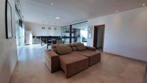 sala de estar con sofá marrón y piano en Suítes bem equipadas e uma hidromassagem para relaxar, en Porto Seguro