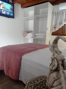 1 dormitorio con 1 cama y TV en la pared en Casa Medieval, en Gramado