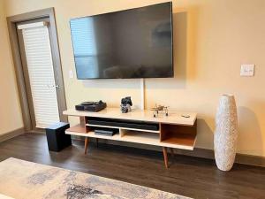 a living room with a large television on the wall at Luxury Suite in the heart of Dallas, a Home away from Home! in Richardson