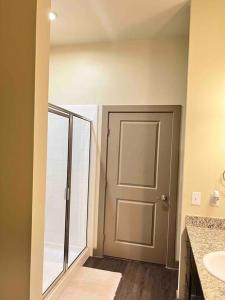 a bathroom with a door and a sink and a toilet at Luxury Suite in the heart of Dallas, a Home away from Home! in Richardson