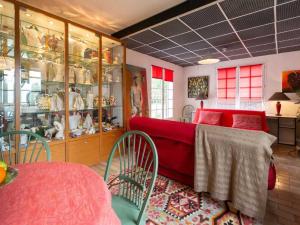 Zimmer mit einer roten Couch und einem Tisch mit Stühlen in der Unterkunft Gîte Dureil, 2 pièces, 4 personnes - FR-1-410-331 in Dureil