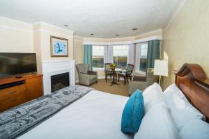 a hotel room with a bed and a television at Inn of the Four Winds Seaside Oceanfront in Seaside