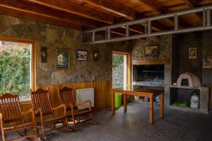 Habitación con mesa, sillas y chimenea. en PATAGONIA RANCH HAUS en San Martín de los Andes