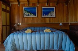 Un dormitorio con una gran cama azul con toallas. en PATAGONIA RANCH HAUS en San Martín de los Andes