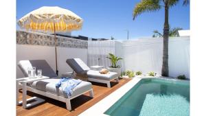 a patio with a pool and a table and chairs at Fennes On Banzai in Kingscliff