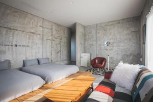 1 dormitorio con 2 camas y sofá en Yanbaru Hostel, en Kunigami