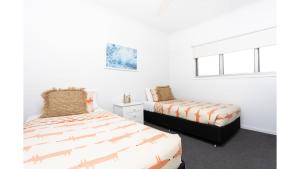 a bedroom with two beds and a window at On Northpoint at Salt in Kingscliff +42 photos