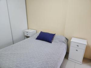 1 dormitorio con 1 cama con almohada azul en departamento temporal La Cañada en Córdoba