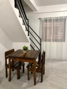 a wooden table and chairs in a room with stairs at Sebastian’s Crib F in Dasmariñas