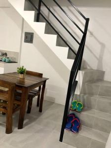a dining room with a table and stairs with flip flops at Sebastian’s Crib F in Dasmariñas