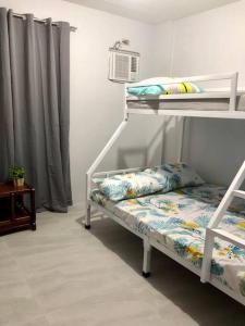 a white bunk bed with a bench in a room at Sebastian’s Crib F in Dasmariñas