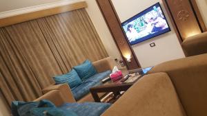 een woonkamer met 2 stoelen en een televisie bij Sheraton Ocean 202 - Private apartments in Caïro