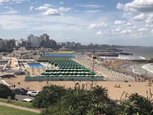 una playa con sombrillas y gente en la playa en LISBOA Departamento Premium en Mar del Plata