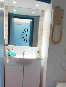 uma casa de banho com um lavatório e um espelho em Studio La «KAZ’ À COCO» Anse Caritan em Sainte-Anne