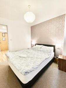 una camera da letto con un grande letto e un copriletto bianco di Lovely 2 - bedroom condo in Manchester City centre a Manchester