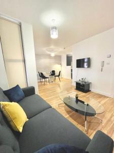 a living room with a couch and a table at Lovely 2 - bedroom condo in Manchester City centre in Manchester