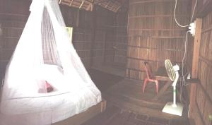 a bedroom with a bed and a desk and a chair at Mambetron Homestay Raja Ampat in Pulau Mansuar