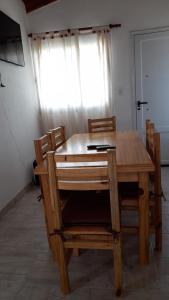 mesa de comedor de madera y sillas con ventana en Casa Villa Zorzal en Villa Larca