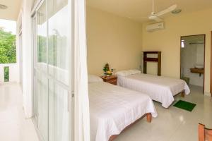 two beds in a room with a window at Hotel las flores in Santa Cruz Huatulco
