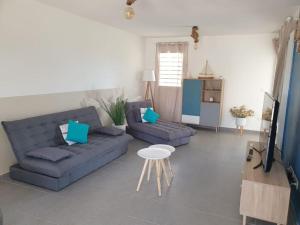 sala de estar con sofá azul y mesa en Mangrov, en Le Moule