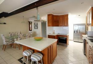 a kitchen with a island in the middle of a room at Beach at your feet in Bargara