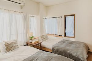 sypialnia z 2 łóżkami i oknem w obiekcie White Space w mieście Kakegawa