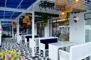a restaurant with white tables and chairs and lights at Cavinton Hotel Malioboro Yogyakarta by Tritama Hospitality in Yogyakarta