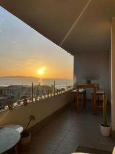 a balcony with a view of the ocean at sunset at Departamento Aqua La Serena in La Serena