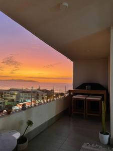 a balcony with a view of the ocean at sunset at Departamento Aqua La Serena in La Serena