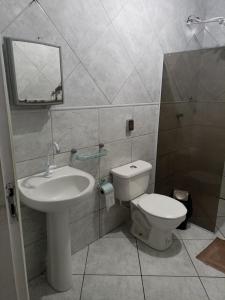 y baño con lavabo, aseo y espejo. en Itapuã Corais Hostel e Pousada, en Salvador