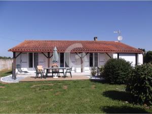 una pequeña casa blanca con mesa y sombrilla en Maison La Jonchère, 4 pièces, 6 personnes - FR-1-357-89 en La Jonchère