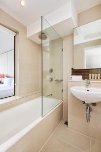 a bathroom with a glass shower and a sink at View Sydney in Sydney