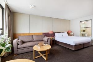 シドニーにあるView Sydneyのベッドとソファ付きのホテルルーム