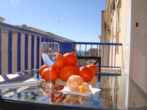 a bowl of oranges on a table with a glass of wine at Torrox Boutique Apartaments - Paraiso Sol in Torrox Costa