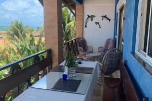 a balcony with a table and chairs and bats on the wall at Sonia Flats Arituba Tropical - Flat vista mar em frente à Praia de Camurupim in Nísia Floresta