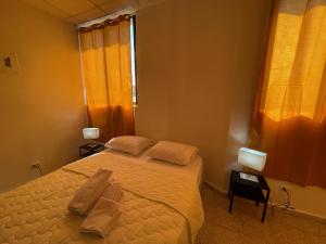 a bedroom with a bed with two towels on it at Hotel Colonial Blanco in Santo Domingo