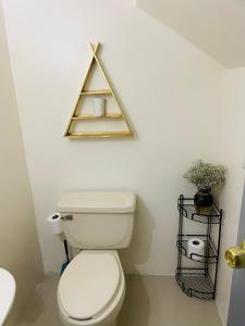 a bathroom with a toilet and a triangle sign on the wall at Casa Castaño Cd Jrz in Ciudad Juárez