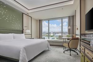 a hotel room with a bed and a large window at Shangri-La Qiantan, Shanghai in Shanghai