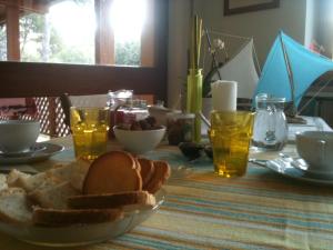 a table with a plate of bread and drinks on it at La Casa di Ulisse B&B in Quercianella