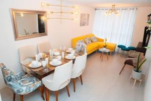 ein Wohnzimmer mit einem Tisch und einem gelben Sofa in der Unterkunft Hermoso departamento de estreno in Lima