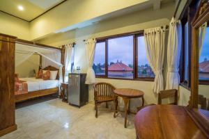 烏布的住宿－Bangbang Guest House Ubud，一间卧室配有一张床、一张桌子和一个窗户。