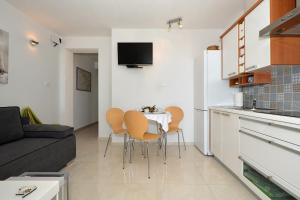 a kitchen and a living room with a table and chairs at Apartments Inge in Seget Vranjica