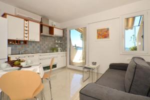 a kitchen and living room with a couch and a table at Apartments Inge in Seget Vranjica