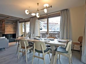 una sala da pranzo con un grande tavolo in legno e sedie di Appartement neuf avec terrasse, SPA, 3 chambres et services hôteliers - Méribel Les Allues - FR-1-613-22 a Méribel