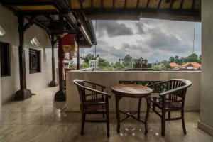 een houten tafel en stoelen in een kamer met uitzicht bij Bangbang Guest House Ubud in Ubud