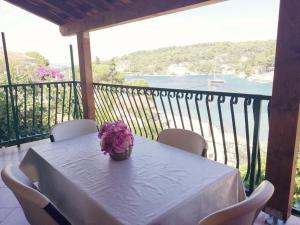 a table with a vase of flowers on a balcony at Apartments Rogac in Rogač